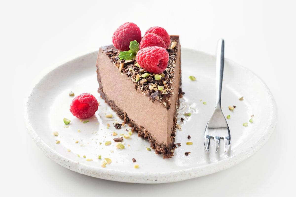 Raw chocolate cheesecake on a white plate.